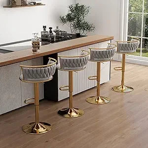 Set of four gray cushioned bar stools with gold bases in a kitchen setting.